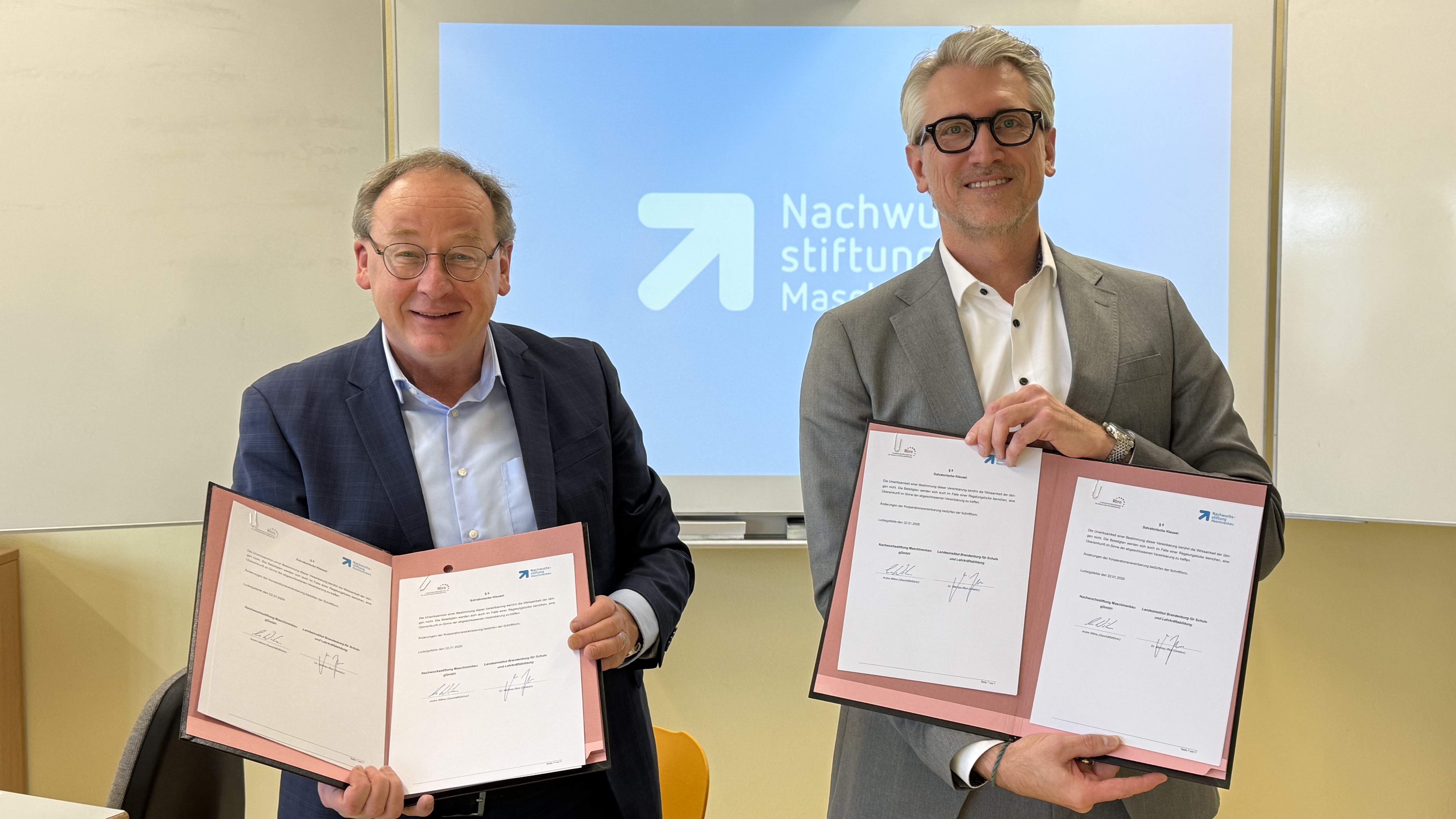 Andre Wilms und Dr. Matthias Iffert halten die unterzeichnete Kooperationsvereinbarung zwischen LIBRA und der Nachwuchsstiftung Maschinenbau.