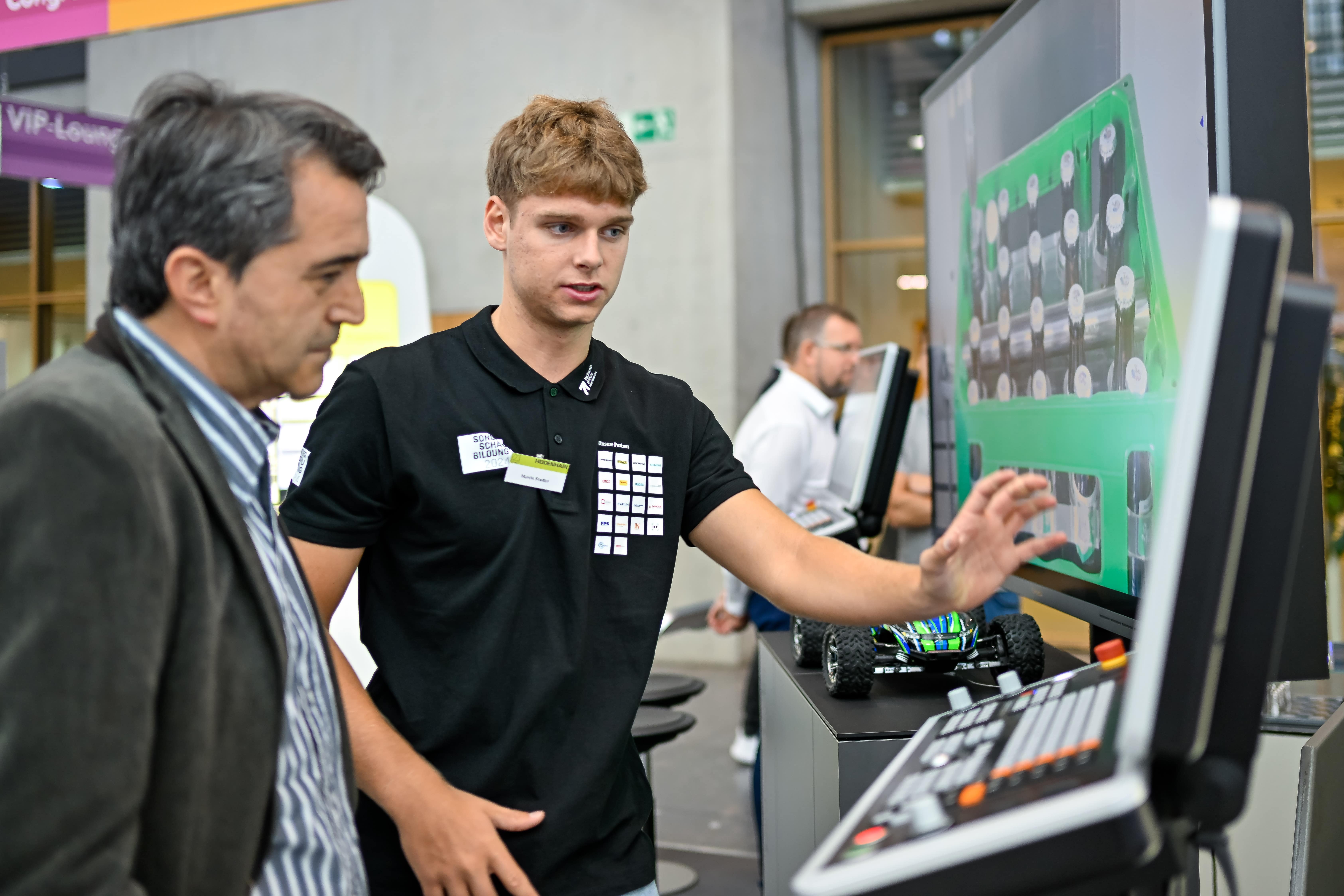 Auszubildender erklärt einem Fachbesucher eine CNC-Prozessvisualisierung auf der Sonderschau Bildung 2025