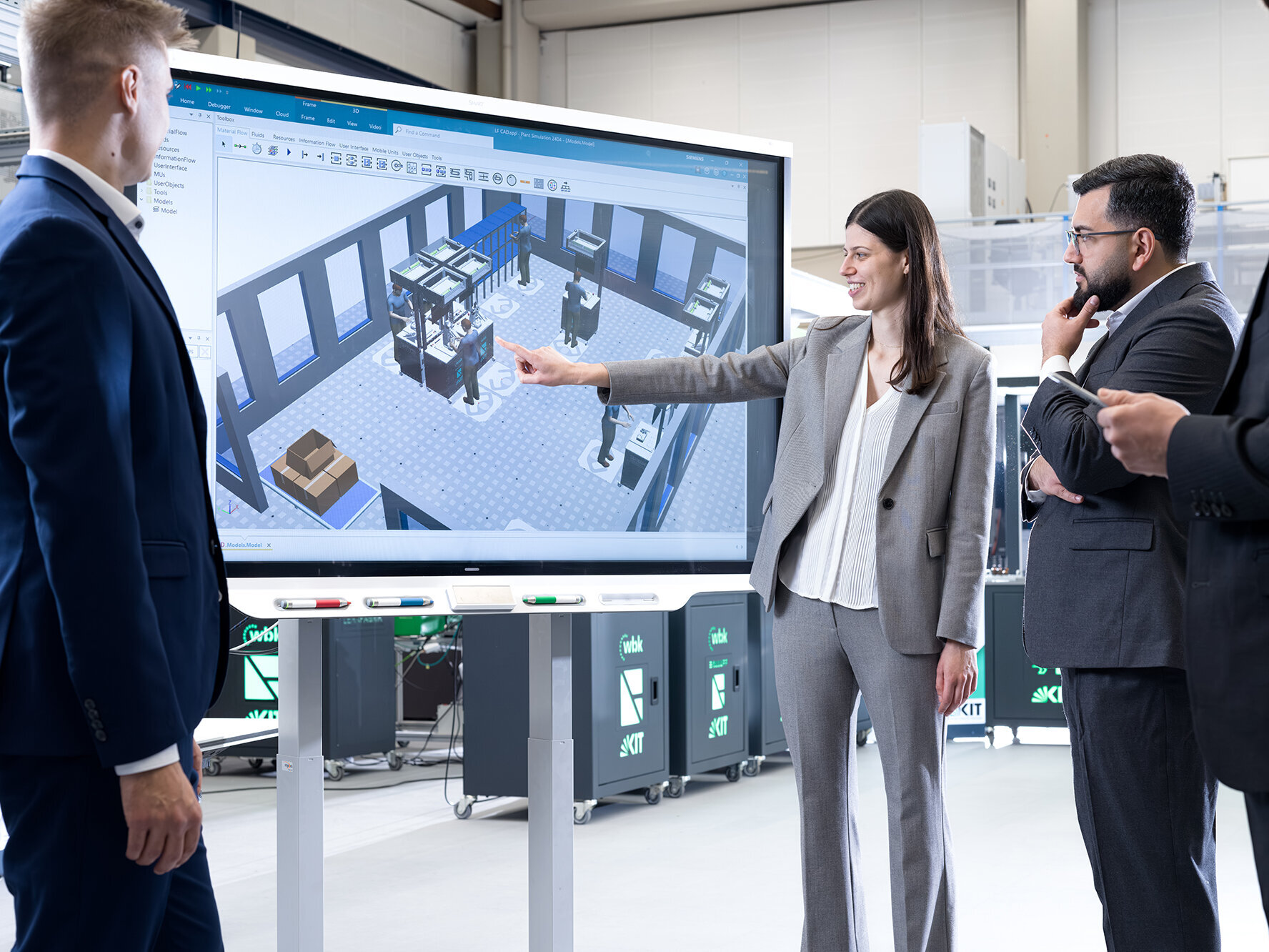 Teilnehmende analysieren eine digital simulierte Produktionsumgebung in der Lernfabrik am KIT zur Verbindung von Lean Management und Industrie 4.0