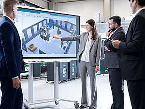 Teilnehmende analysieren eine digital simulierte Produktionsumgebung in der Lernfabrik am KIT zur Verbindung von Lean Management und Industrie 4.0