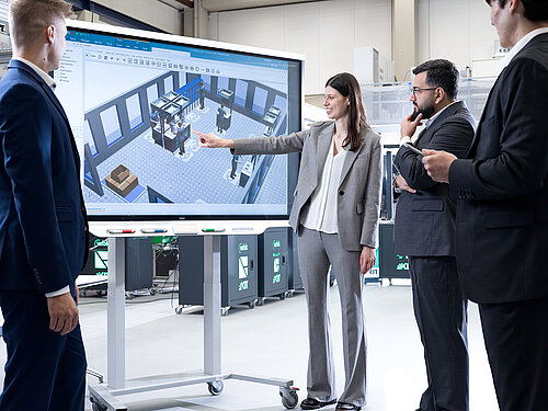 Teilnehmende analysieren eine digital simulierte Produktionsumgebung in der Lernfabrik am KIT zur Verbindung von Lean Management und Industrie 4.0