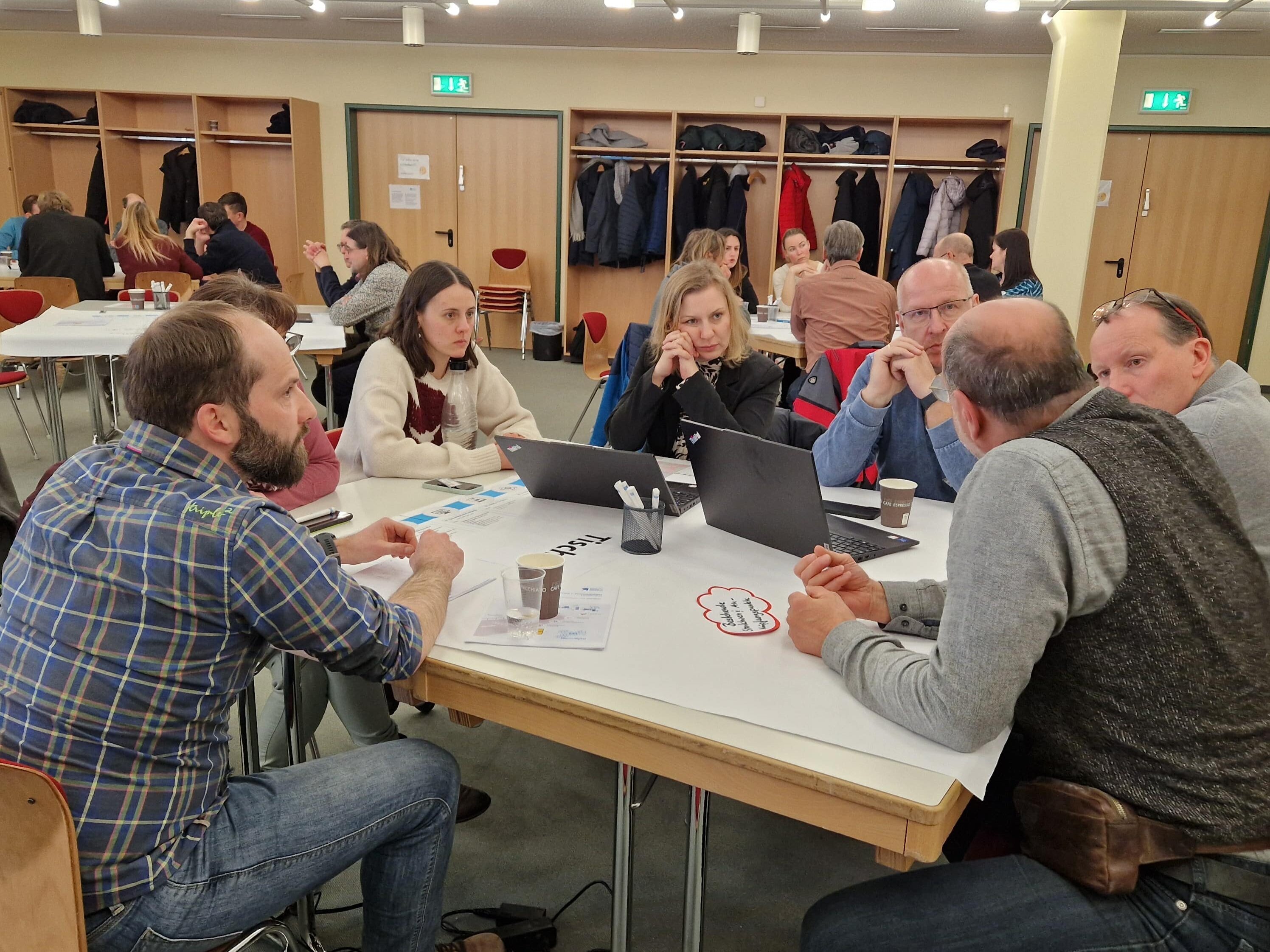 Teilnehmer der Auftaktveranstaltung zur Zusatzqualifikation Digitale Fertigungsprozesse sitzen an einem Tisch und diskutieren über die digitale Transformation in der Ausbildung