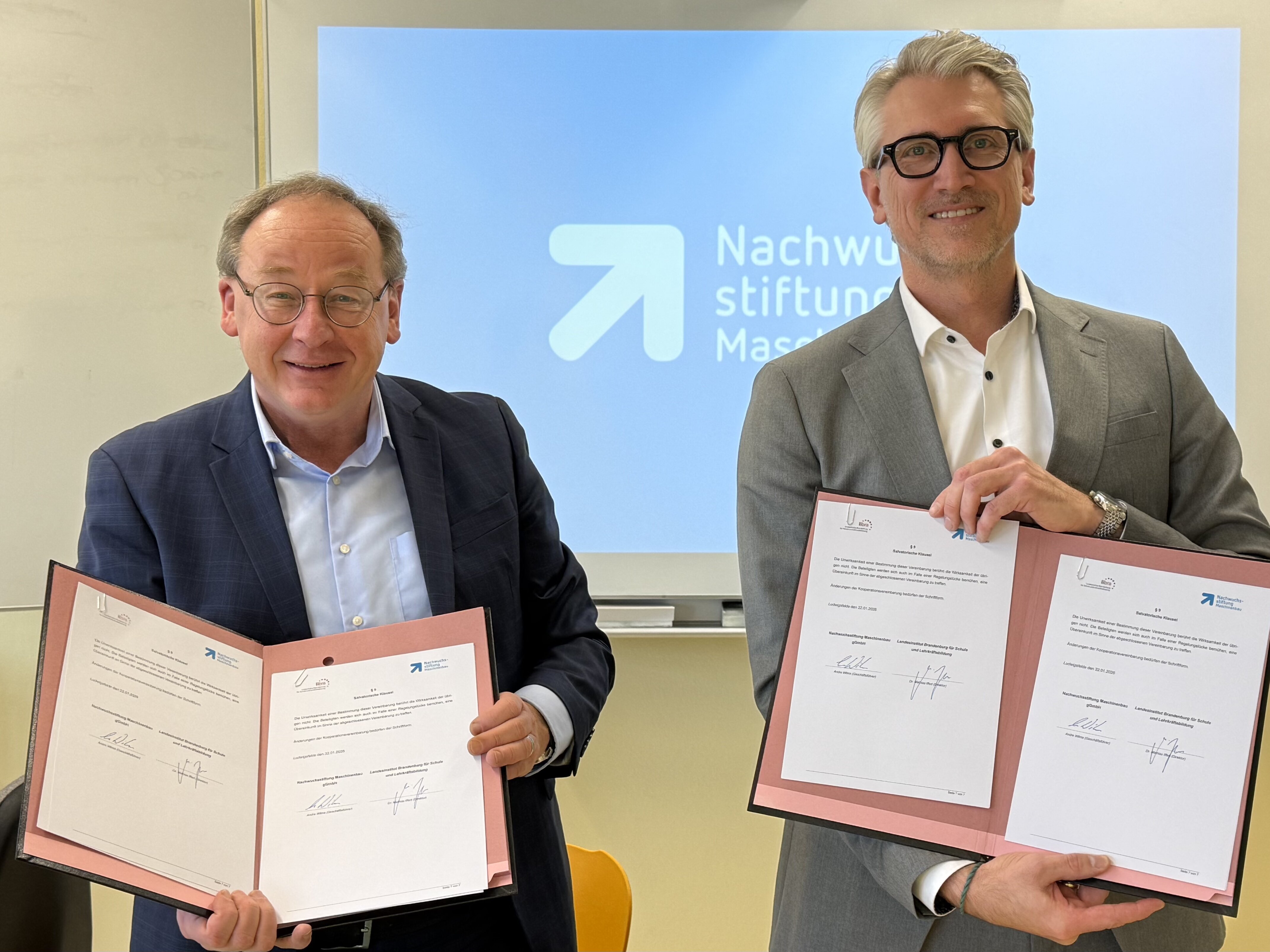 Andre Wilms und Dr. Matthias Iffert halten die unterzeichnete Kooperationsvereinbarung zwischen LIBRA und der Nachwuchsstiftung Maschinenbau.